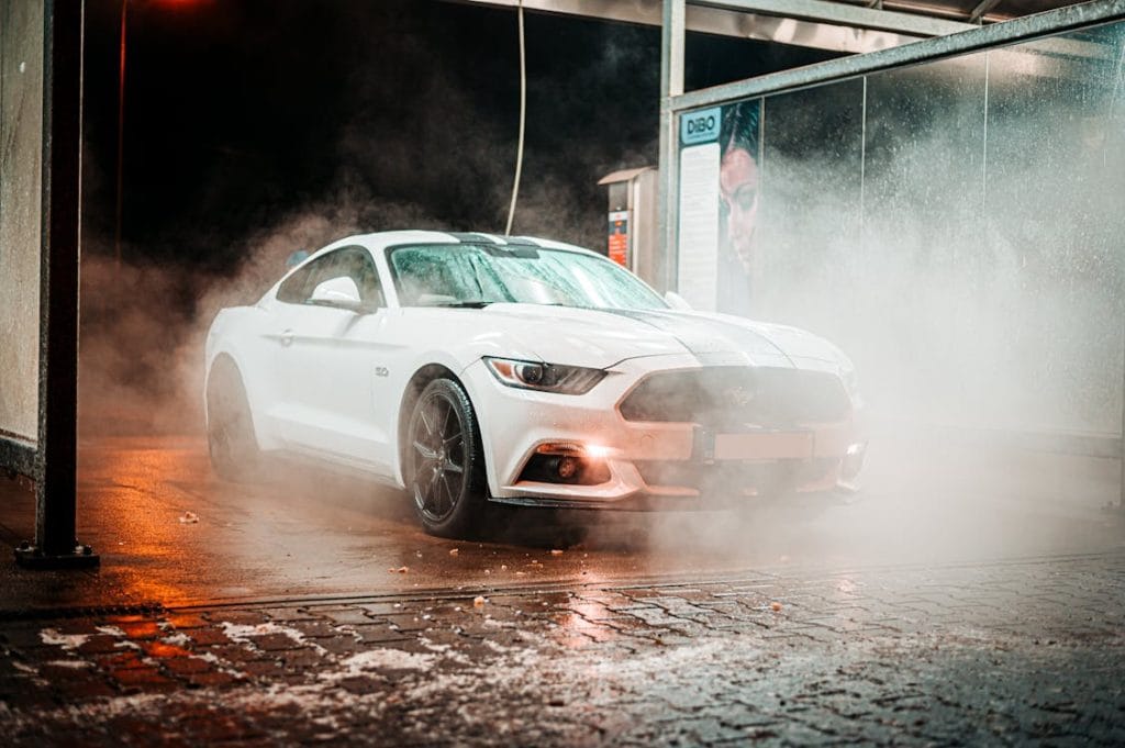 Ceramic Coating vs Wax: Which Is Right for Your Car? (2026 Guide) 3 White sports car lit through drifting steam