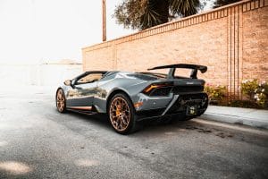 Blog 9 Silver sports car with a rear wing beside a brick wall
