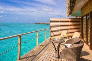 Waterfront resort deck with lounge chairs above turquoise water